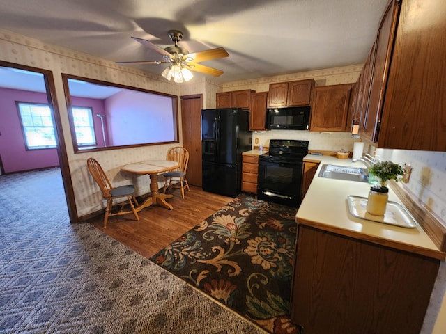 kitchen with dark hardwood / wood-style flooring, sink, ceiling fan, and black appliances