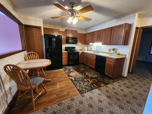 kitchen with ceiling fan, sink, dark wood-type flooring, a textured ceiling, and black appliances