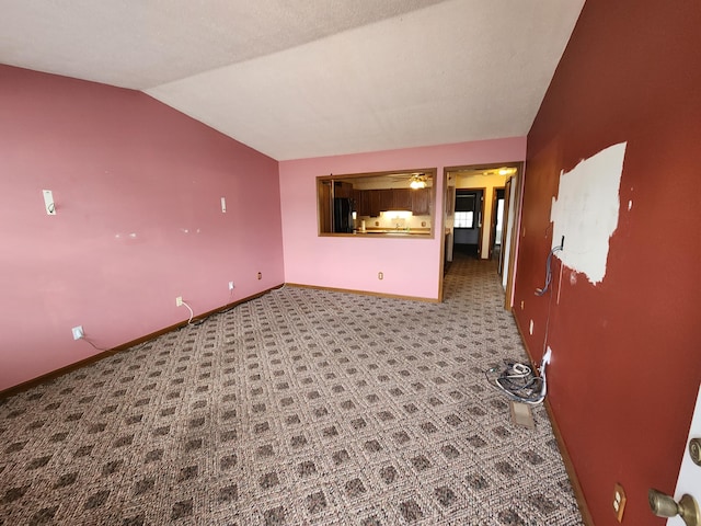 unfurnished living room featuring carpet flooring and vaulted ceiling