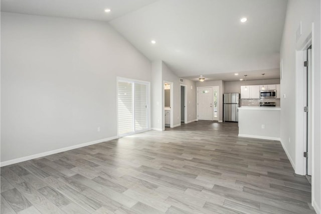 unfurnished living room with light hardwood / wood-style flooring and high vaulted ceiling