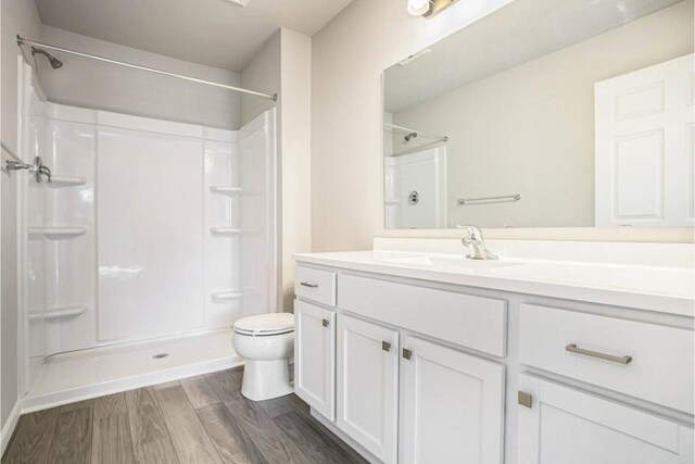 bathroom with vanity, toilet, and a shower