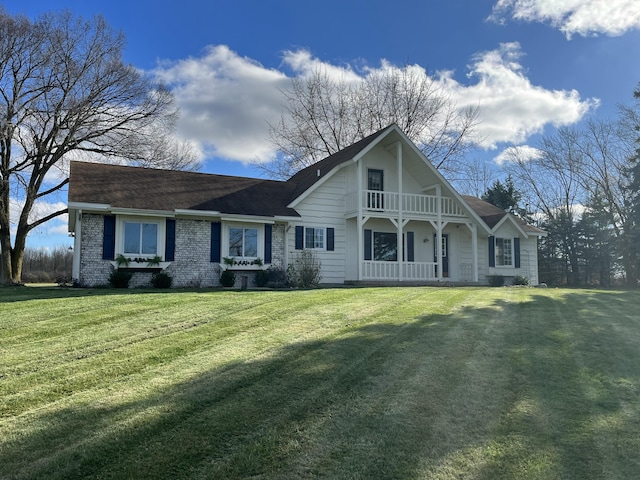 view of front of house featuring a front lawn and a balcony