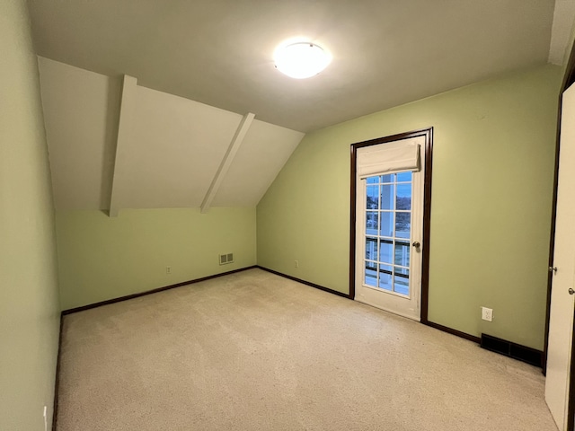 bonus room with light carpet and vaulted ceiling