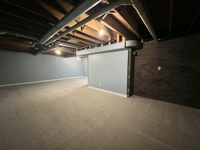 basement with brick wall and carpet flooring