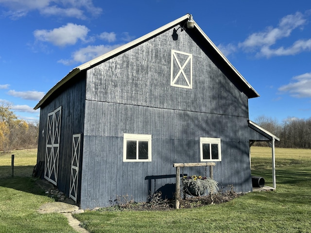 view of side of property with a lawn and an outdoor structure