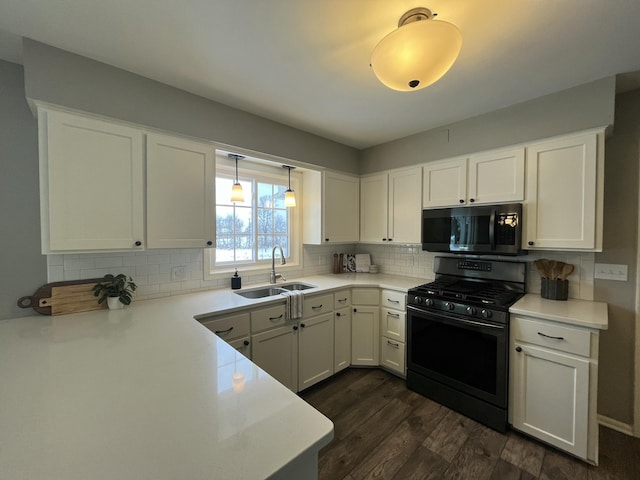 kitchen with black range with gas cooktop, sink, and white cabinets