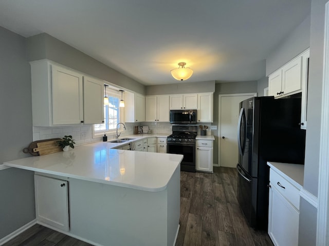 kitchen featuring black appliances, kitchen peninsula, and white cabinets