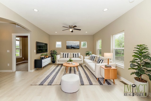 living room with light hardwood / wood-style floors and ceiling fan