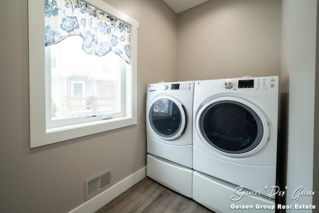 washroom featuring hardwood / wood-style flooring and washer and clothes dryer