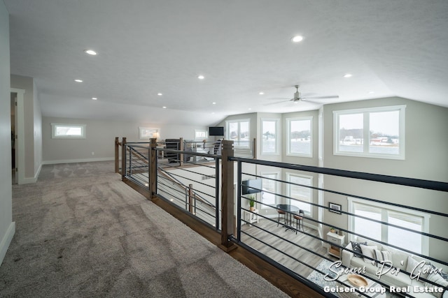 hallway featuring a wealth of natural light and vaulted ceiling