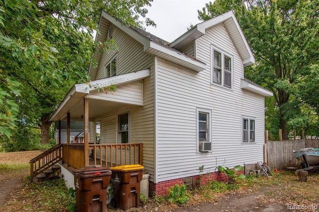 view of property exterior featuring cooling unit and a porch