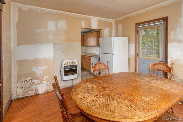 dining area with heating unit and light hardwood / wood-style floors