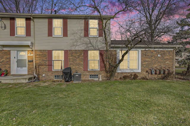 back house at dusk with a lawn