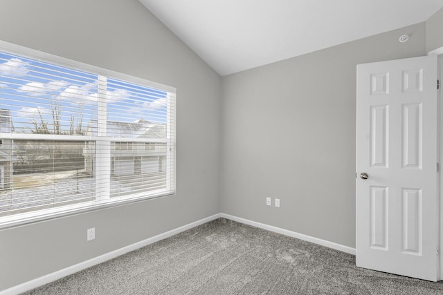 carpeted spare room with lofted ceiling