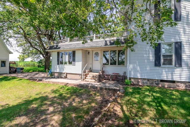 view of front of house featuring a front lawn and a patio area