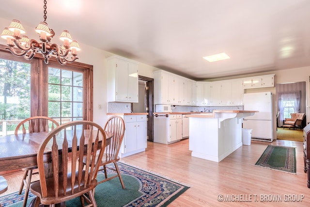 dining room with light hardwood / wood-style flooring and an inviting chandelier