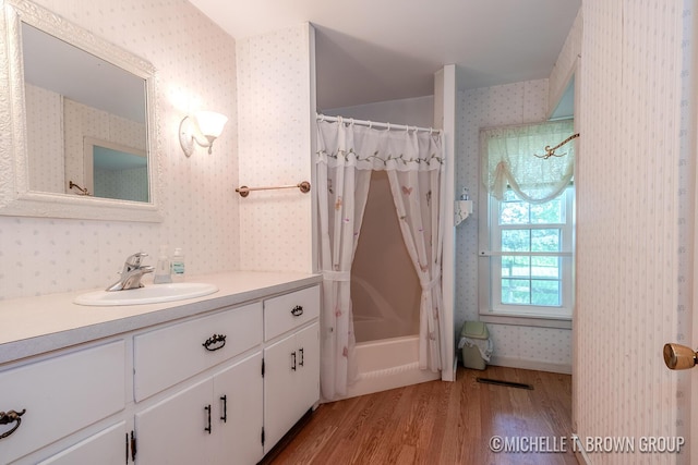 bathroom with vanity, wood-type flooring, and shower / tub combo