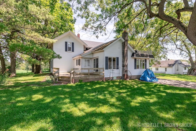 rear view of house with a wooden deck and a yard