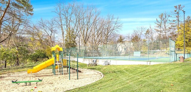 view of jungle gym featuring tennis court and a yard