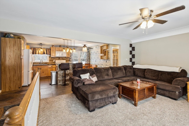 living room featuring ceiling fan, sink, and light carpet