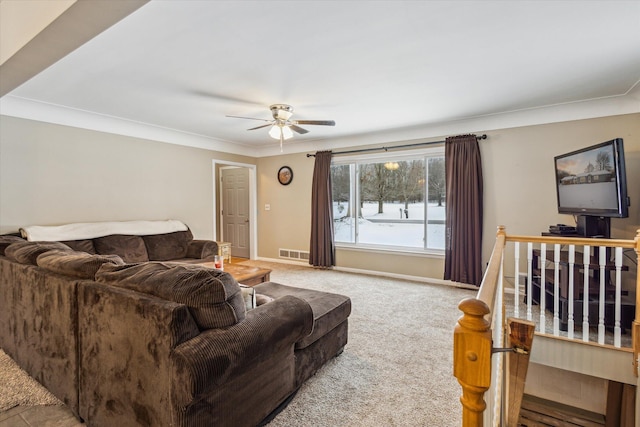 living room with ceiling fan, ornamental molding, and light carpet