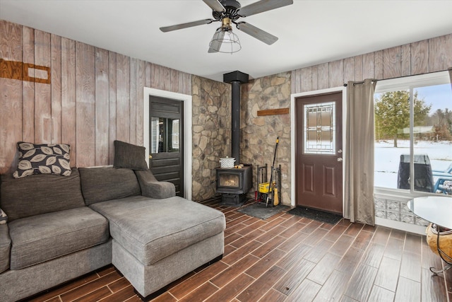 living room featuring a wood stove and ceiling fan