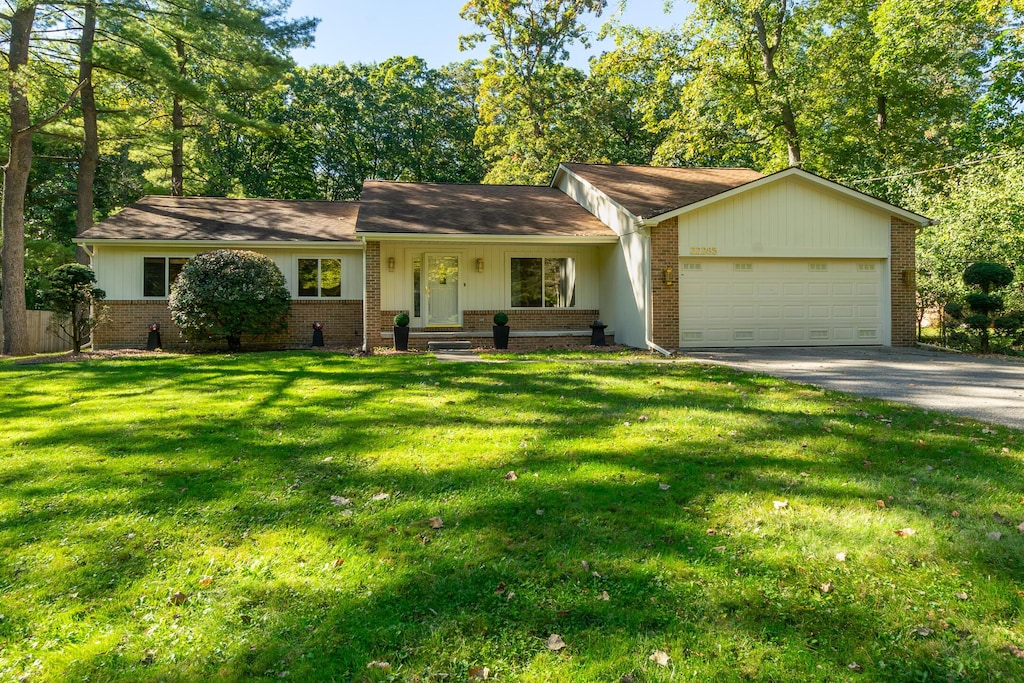 ranch-style home featuring a front lawn and a garage