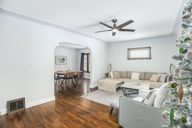 living room with ceiling fan and dark wood-type flooring