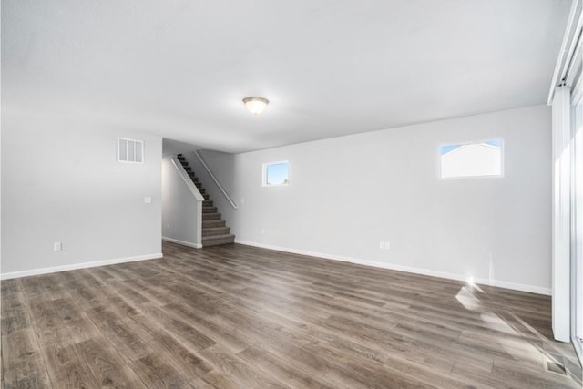 basement with dark hardwood / wood-style flooring and a healthy amount of sunlight