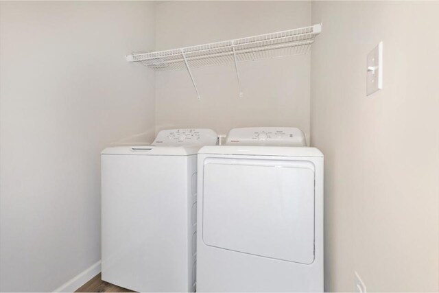 laundry room featuring washer and clothes dryer and wood-type flooring