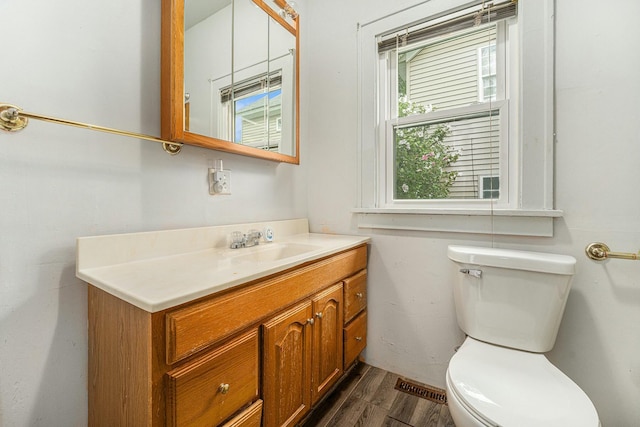 bathroom with wood-type flooring, vanity, and toilet