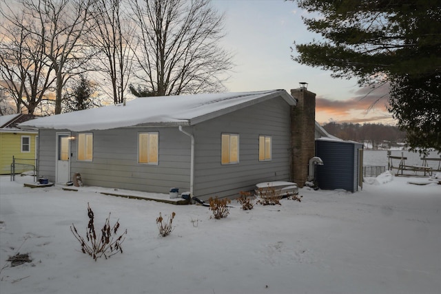 view of snow covered back of property