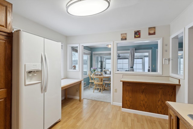 kitchen with white fridge with ice dispenser and light hardwood / wood-style flooring