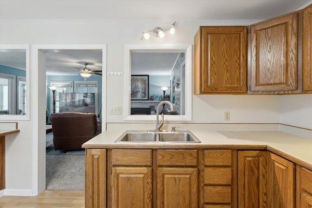 kitchen featuring ceiling fan, light wood-type flooring, and sink