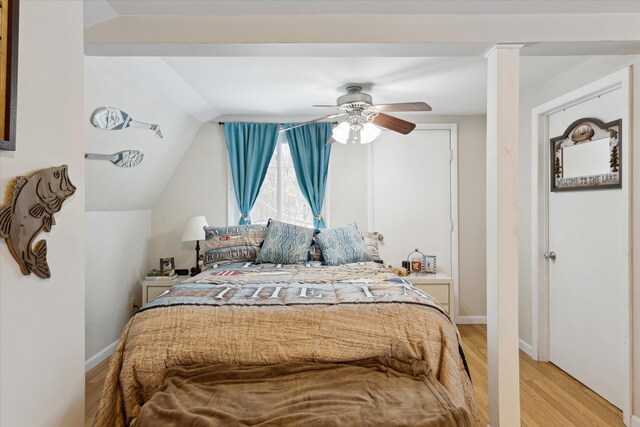 bedroom with ceiling fan, light hardwood / wood-style floors, and lofted ceiling