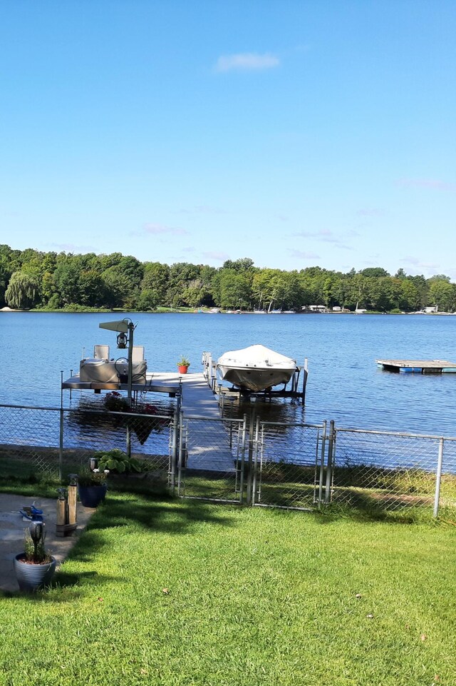 dock area featuring a water view and a lawn