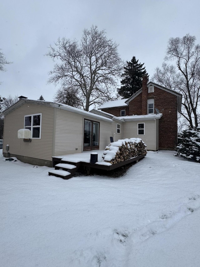 view of snow covered back of property