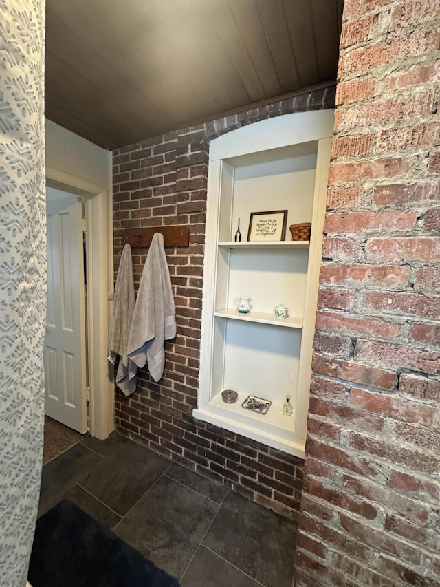 mudroom with brick wall