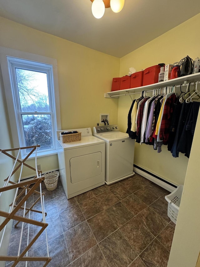 clothes washing area with separate washer and dryer and a baseboard radiator