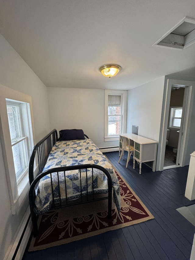 bedroom featuring baseboard heating, multiple windows, and dark hardwood / wood-style flooring