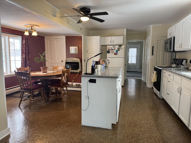 kitchen with white appliances, ceiling fan with notable chandelier, a baseboard radiator, white cabinetry, and heating unit