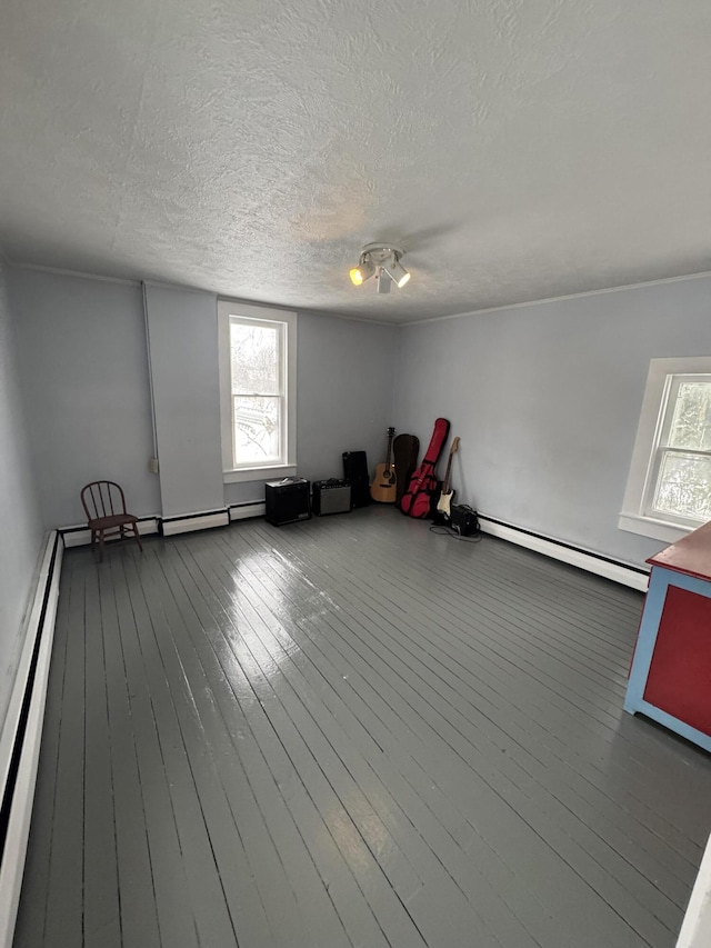 misc room with a textured ceiling, wood-type flooring, and a baseboard radiator