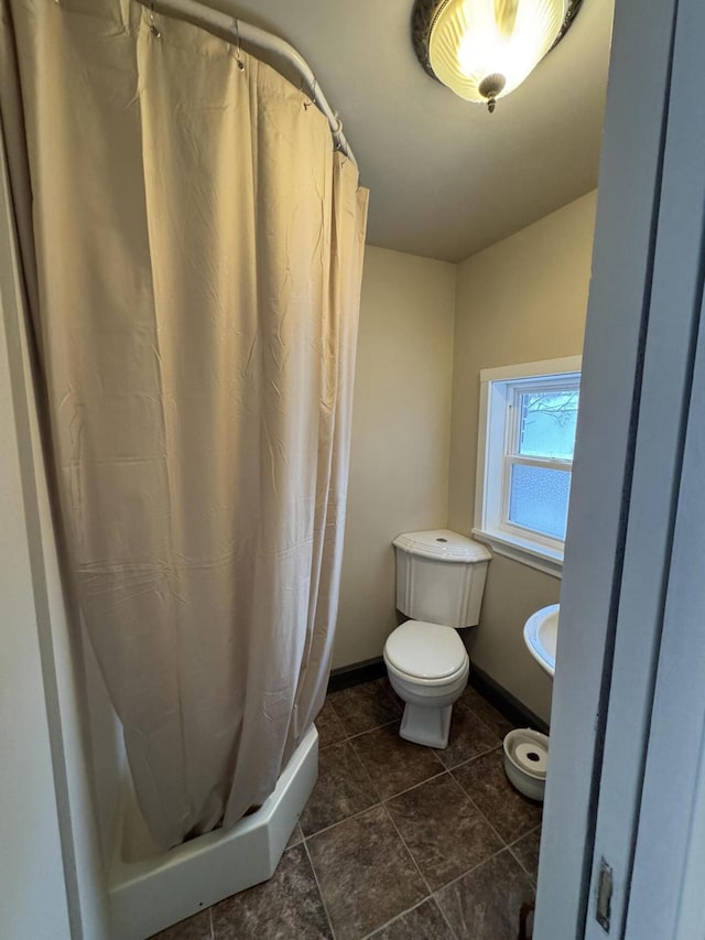 bathroom with a shower with curtain and toilet