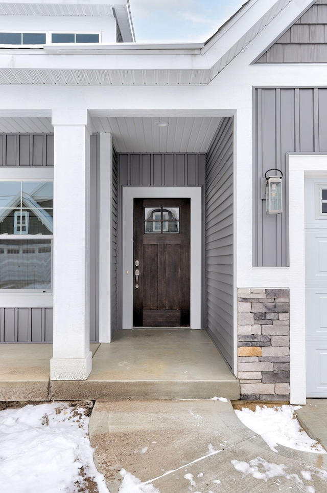 snow covered property entrance with covered porch