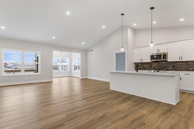 kitchen featuring a center island with sink, white cabinets, and pendant lighting