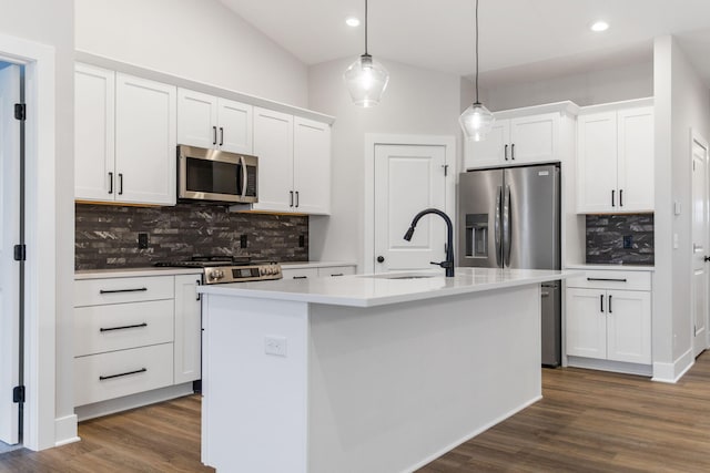 kitchen with white cabinetry, a center island with sink, hanging light fixtures, and appliances with stainless steel finishes