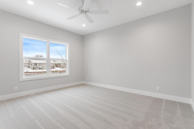 carpeted spare room featuring ceiling fan