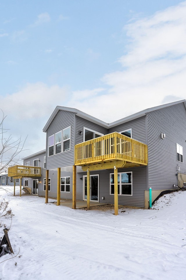 snow covered property with a deck