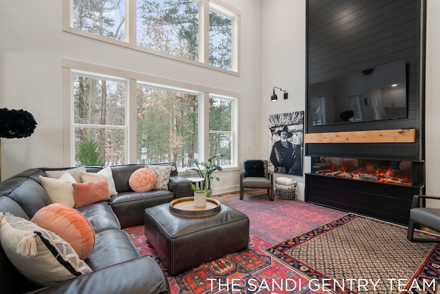 living room with a fireplace and a high ceiling