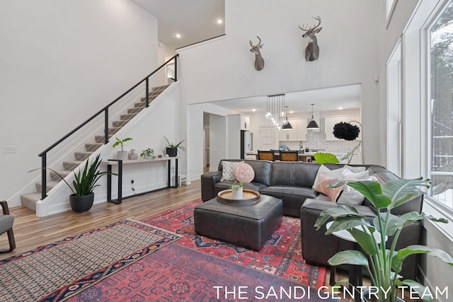 living room featuring a towering ceiling and hardwood / wood-style flooring